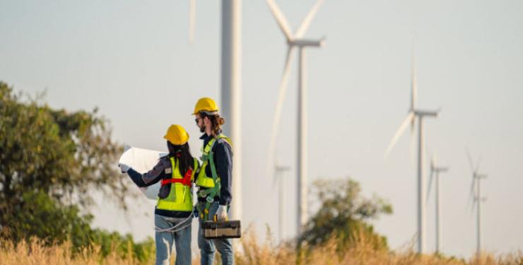 technician walking at wind turbine farm