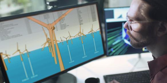technician working working on software looking at the arrangement of wind turbines on a wind farm